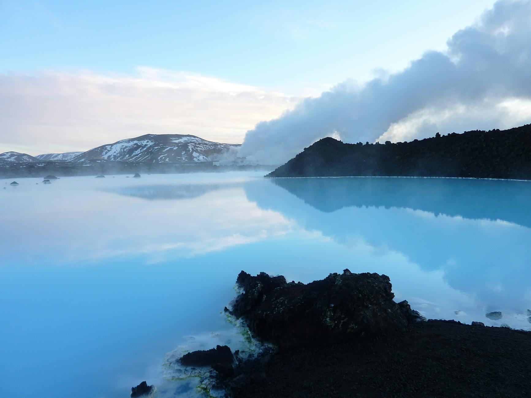 calm body of water surrounded by mountains