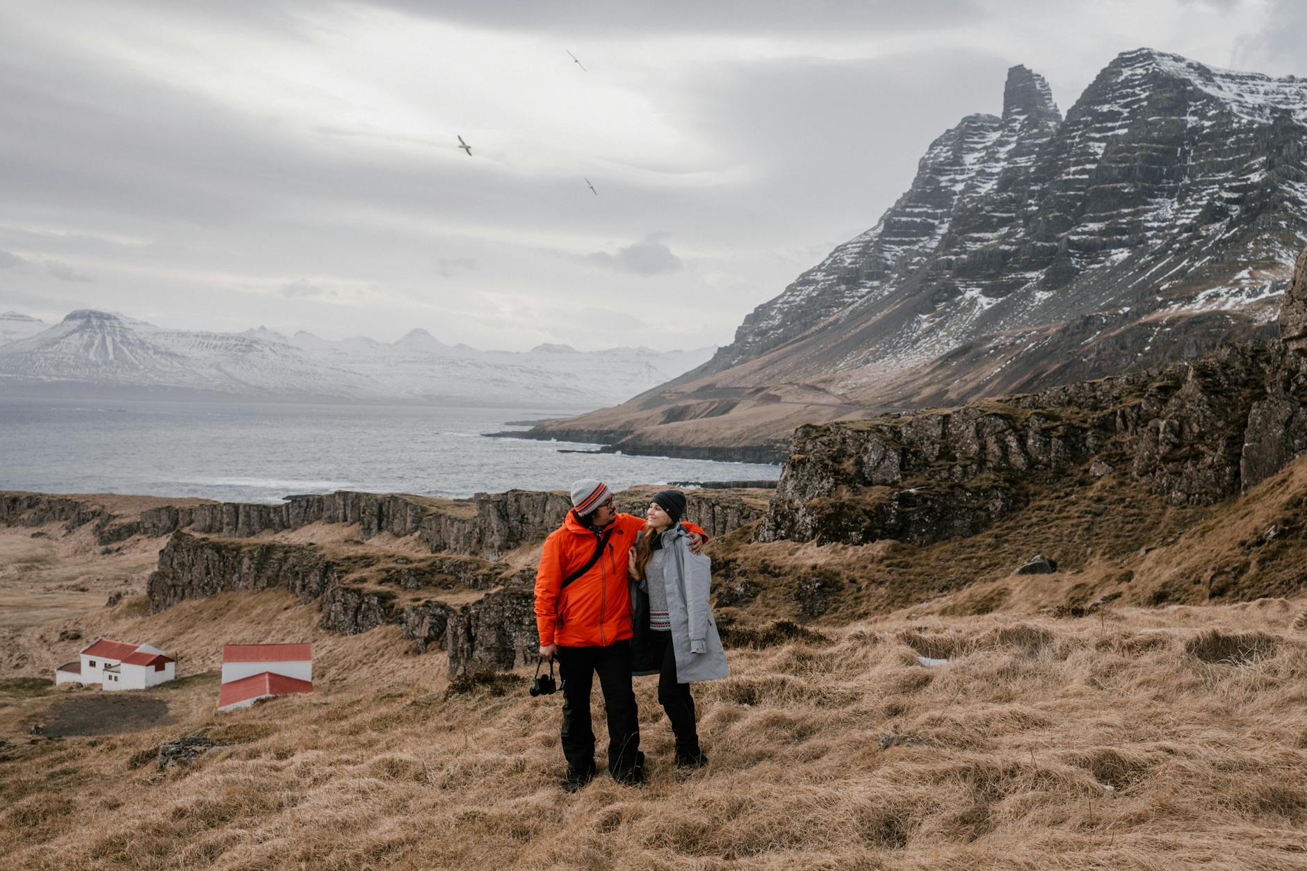 a couple standing on a hay field